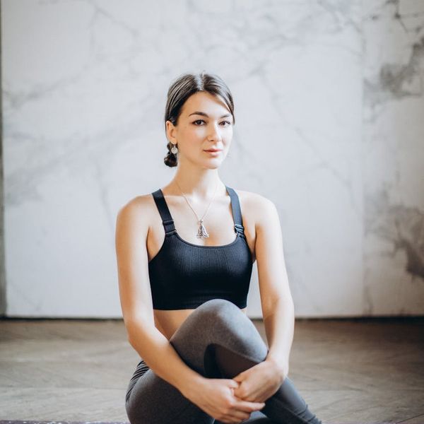 Person holding a balanced yoga pose against a dark, serene background.
